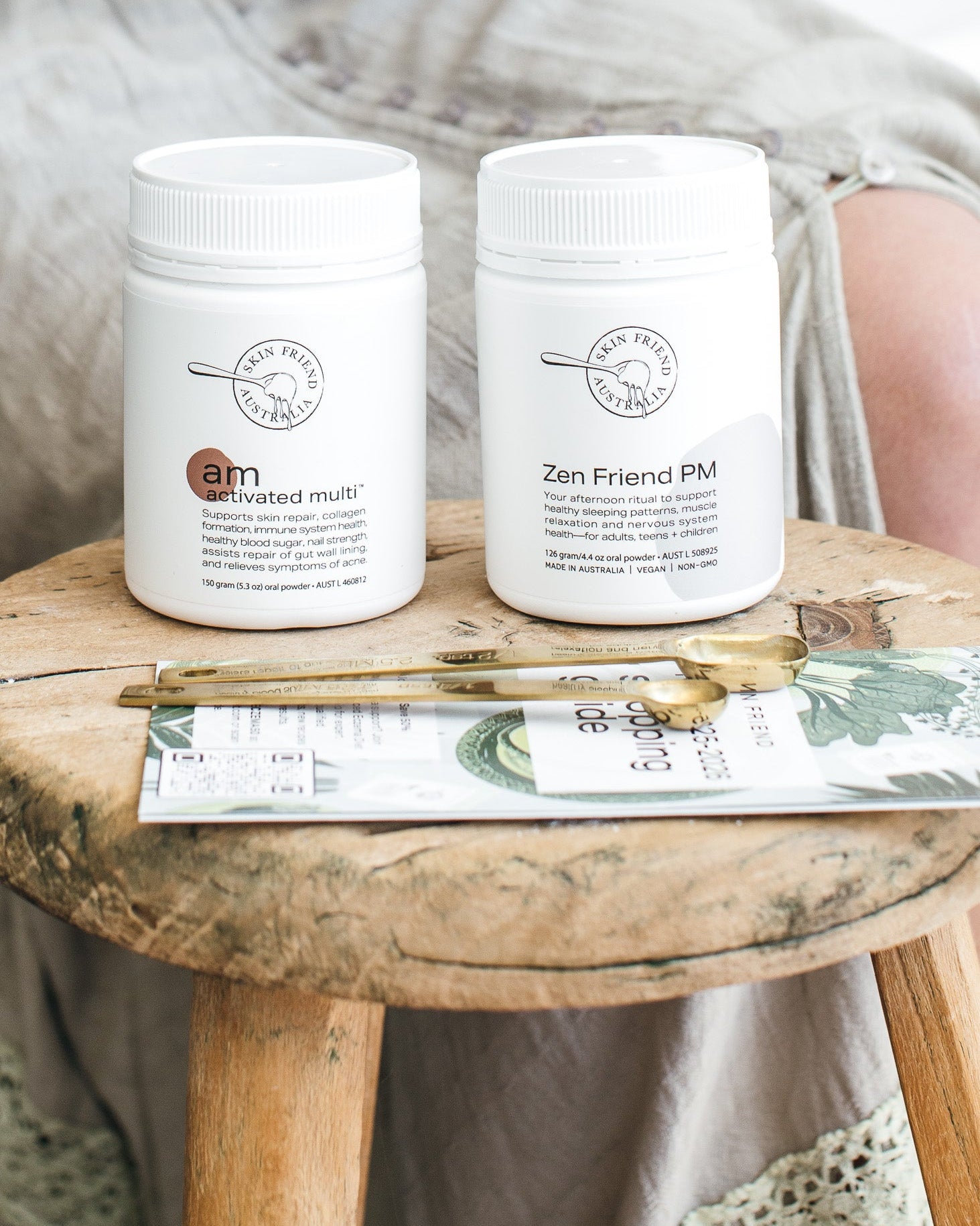 Two white jars labeled 'am' and 'pm' on a wooden stool with a magazine underneath.