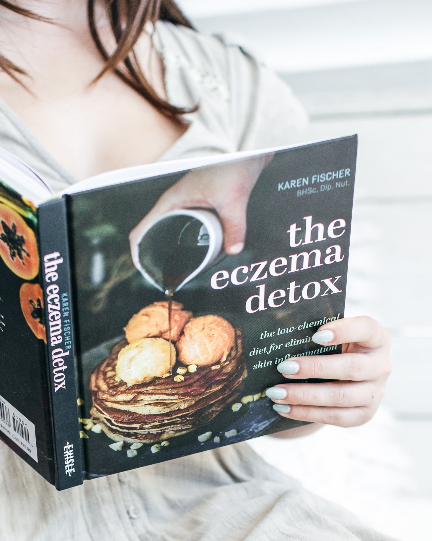 Person holding a book titled 'The Eczema Detox' by Karen Fischer.