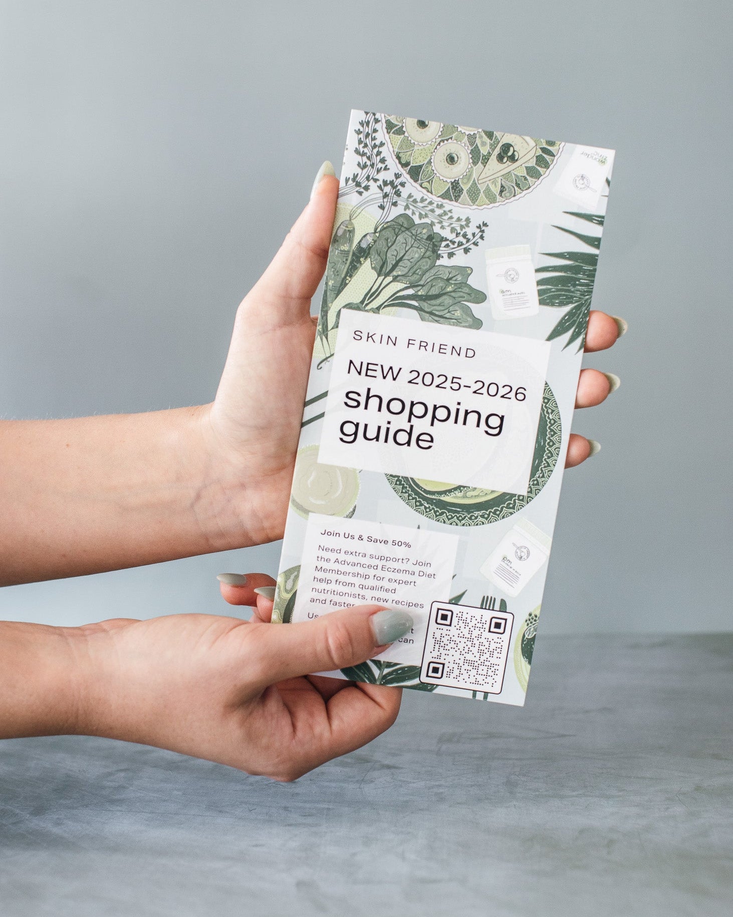 Hand holding a 'Skin Friend' shopping guide against a gray background